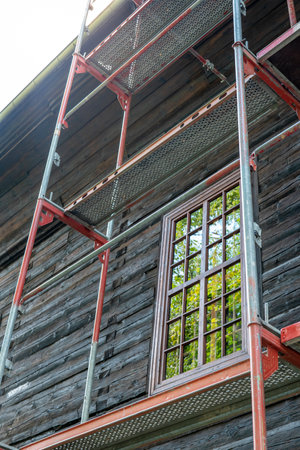 Renovation of an old historic wooden church. Scaffolding set up against the wall of the buildingの写真素材