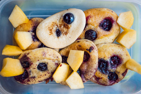 Gluten-free pancakes with blueberries accompanied by sliced ââapple and carrot. Healthy diet. lunch boxesの写真素材