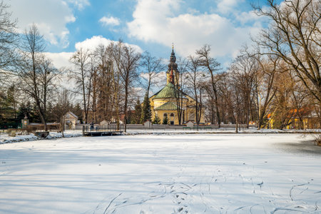 View of the frozen, snow-covered Pond in the City Park in AndrychÃ³w. Church in the background. Lesser Poland Voivodeshipの写真素材
