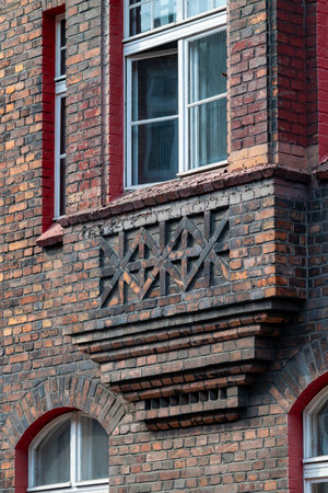 Brick facade of a tenement house in a workers' housing estate. Beautiful window detail. White window frames. Bay windows. Historic housing estate Katowice Nikiszowiec. Polandの写真素材