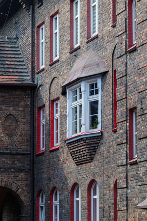 Brick facade of a tenement house in a workers' housing estate. Beautiful window detail. White window frames. Bay windows. Historic housing estate Katowice Nikiszowiec. Polandの写真素材