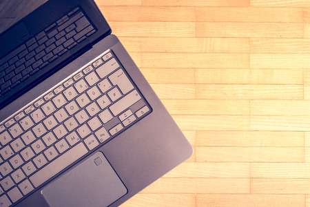 Cutout of a modern laptop keyboard on the wooden floor with text spaceの写真素材