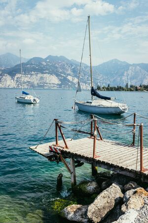 Wooden dock and sailing boats at the coastlineの写真素材