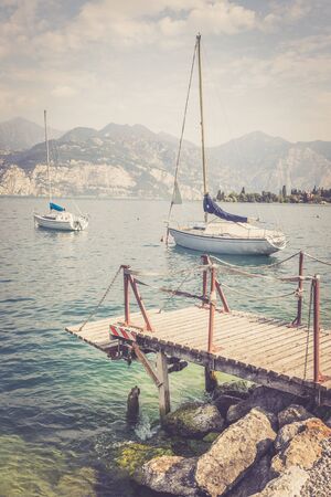 Wooden dock and sailing boats at the coastlineの写真素材