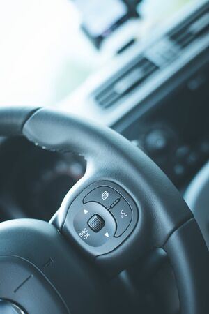 Close up of a steering wheel with remote control, blurry dashboardの写真素材