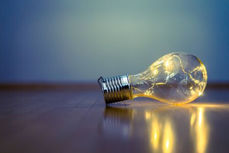 LED light bulb is lying on the wooden floor. Symbol for ideas and innovation. Copy space.の写真素材