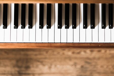 Vintage wooden piano. Keys in the foreground, wooden floor in the blurry backgroundの写真素材