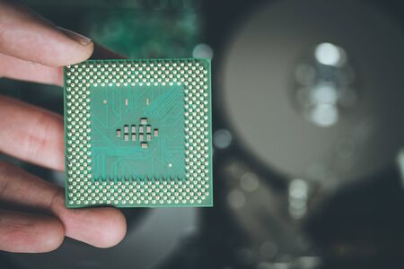 Male hand is holding a cpu, close up; Computer technology.の写真素材