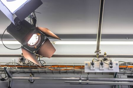 Professional orange studio spotlight hanging on the ceiling.の写真素材