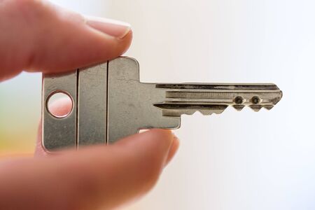 Holding a house key in the hand: New home and property.の写真素材