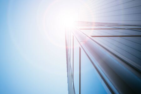 Modern skyscraper out of glass, blue sky and sunbeamの写真素材