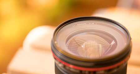 Close up picture of a professional optic photo lens. Smooth blurry background, warm colors. の写真素材