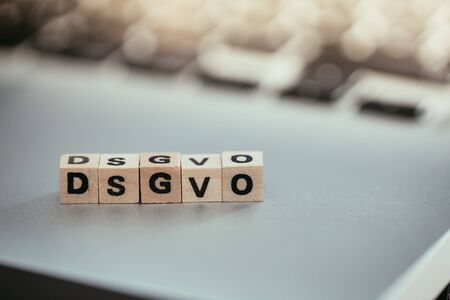 Wooden cubes with the letters âDGSVOâ for Datenschutzgrundverordnung are lying on a laptopの写真素材