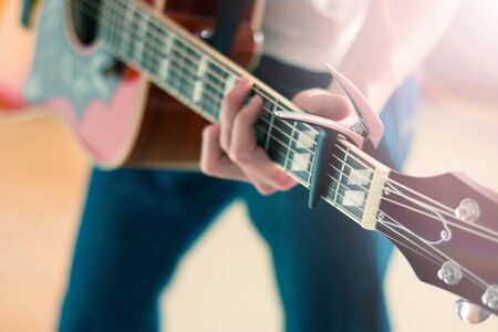 Young man playing a sunburst western guitar: cut out, blurryの写真素材