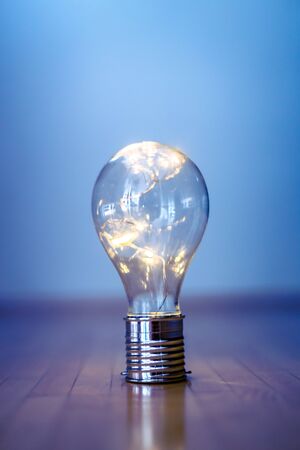 LED light bulb is lying on the wooden floor. Symbol for ideas and innovation. Copy space.