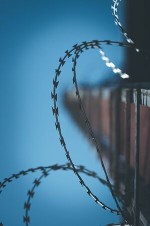 Close up perspective of barbed wire in the prison or on a military baseの写真素材