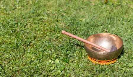 Metal singing bowls in the grass of the own garden, zenの写真素材