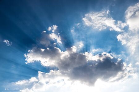 Cloud and bright sunbeams on a blue skyの写真素材