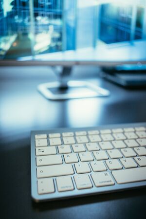 Freelancerâs workplace: Keyboard in the foreground, blurry screen in the backgroundの写真素材