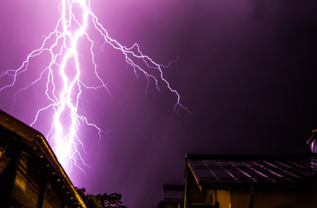 Powerful Lightning on the cloudy sky, building in foreground, Austriaの写真素材