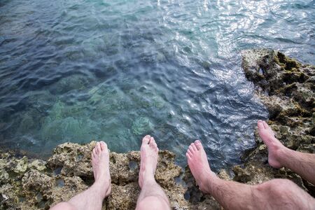 Legs of two men on the beach, relax