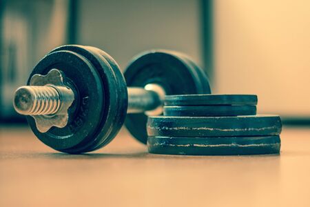 Black bar bell on the wooden floor, physical exerciseの写真素材