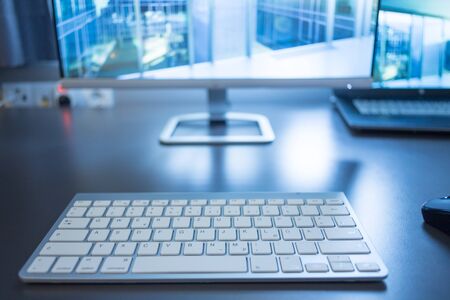 Freelancerâs workplace: Keyboard in the foreground, blurry screen in the backgroundの写真素材