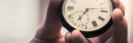 Time goes by: Man is holding a vintage watch in his hand, business context, copy spaceの写真素材