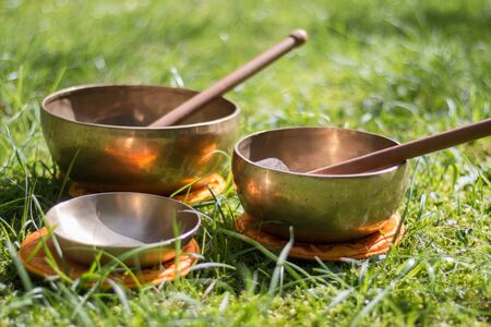 Set of metal singing bowls in the grass of the own garden, zenの写真素材