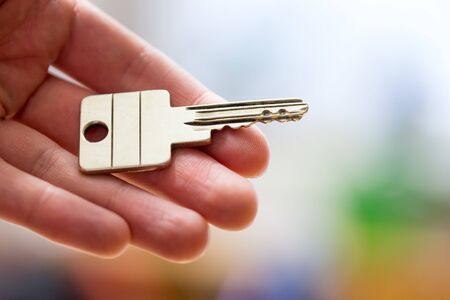 Holding a house key in the hand: New home and property.の写真素材