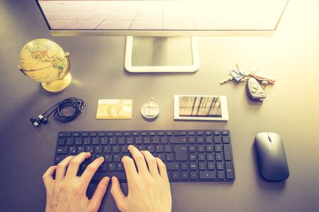 Workplace of a freelancer: Arrangement of computer, keyboard, credit card, compass, keys and globeの写真素材