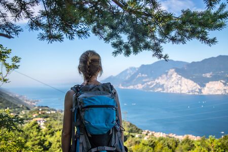 Young girl stands happily on Monte Baldo and enjoys the view. Hiking in Italy.の写真素材