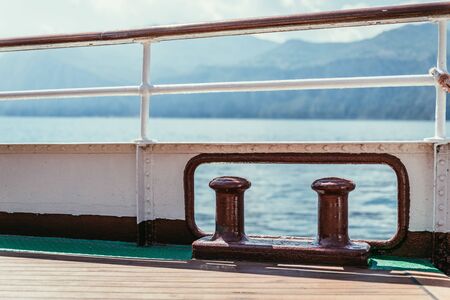 Railing of a boat, boat tour. Blue water and mountain range, Lago di Garda, Italyの写真素材