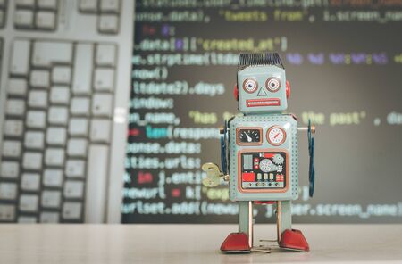 Symbol for a chatbot or social bot and algorithms, program code in the backgroundの写真素材