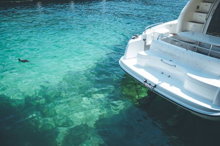 Rear part of a yacht at the harbour, clear blue waterの写真素材