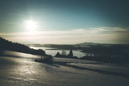 Lake, snowy fields and sundown: scenery at Wallersee, Austriaの写真素材