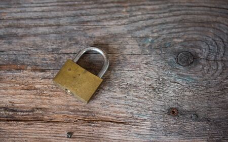 Padlock is lying on rustic wooden desk, close upの写真素材
