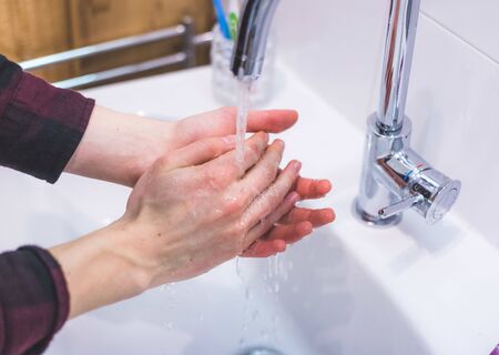 Close up washing hands in the bathroom. Prevention against flu or corona.