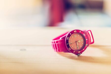 Times goes by, pink watch on a wood shelfの写真素材