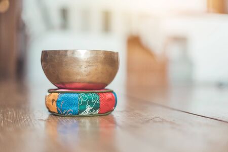 Metal singing bowl on a rustic wooden floor.の写真素材