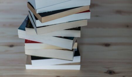 Stack of books on wooden background, knowledge and science の写真素材