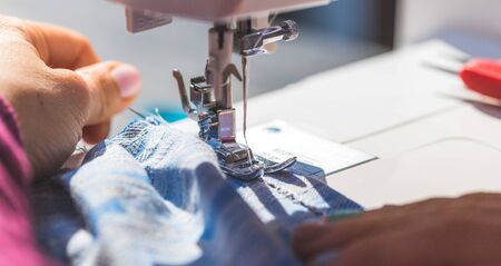 Close up of sewer working with textile and sewing needle