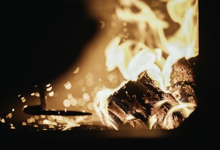 Blaze fire flame in oven, poking stick and sparksの写真素材