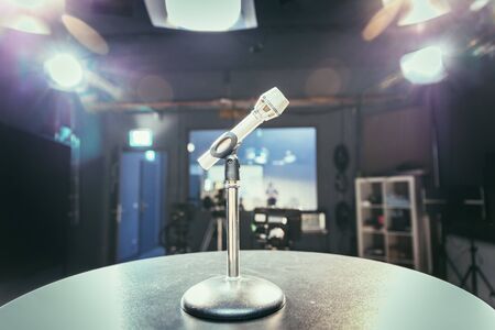 Metal microphone in the studio, studio lights in the blurry backgroundの写真素材