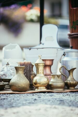 Antique teapots and cups on a flea market, outdoors