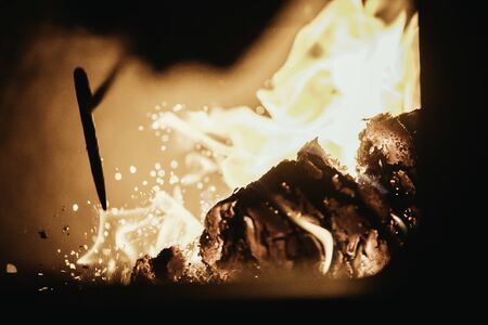 Blaze fire flame in oven, poking stick and sparksの写真素材