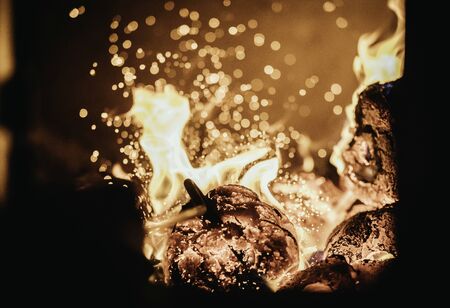 Blaze fire flame in oven, poking stick and sparksの写真素材