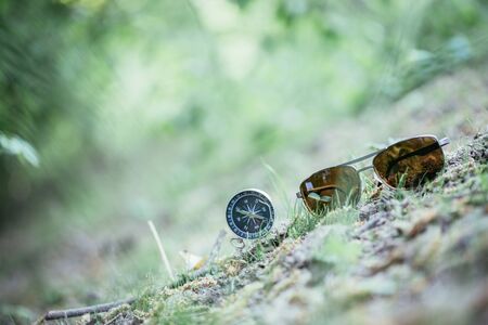 Vintage compass and sunglasses lying on the floor. Adventure and discovery concept. の写真素材
