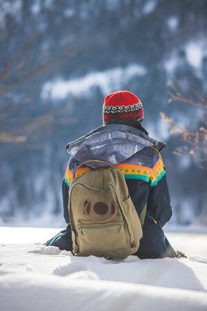 Beautiful Caucasian girl is sitting in the snow. Winter landscape, Austriaの写真素材