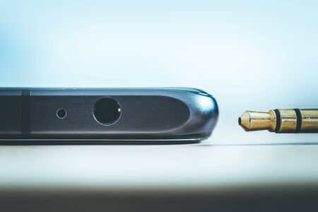 Connection 3.5mm audio jack to a black mobile phone.の写真素材